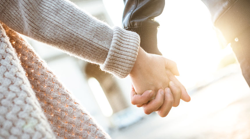 two people holding hands in a sunny day