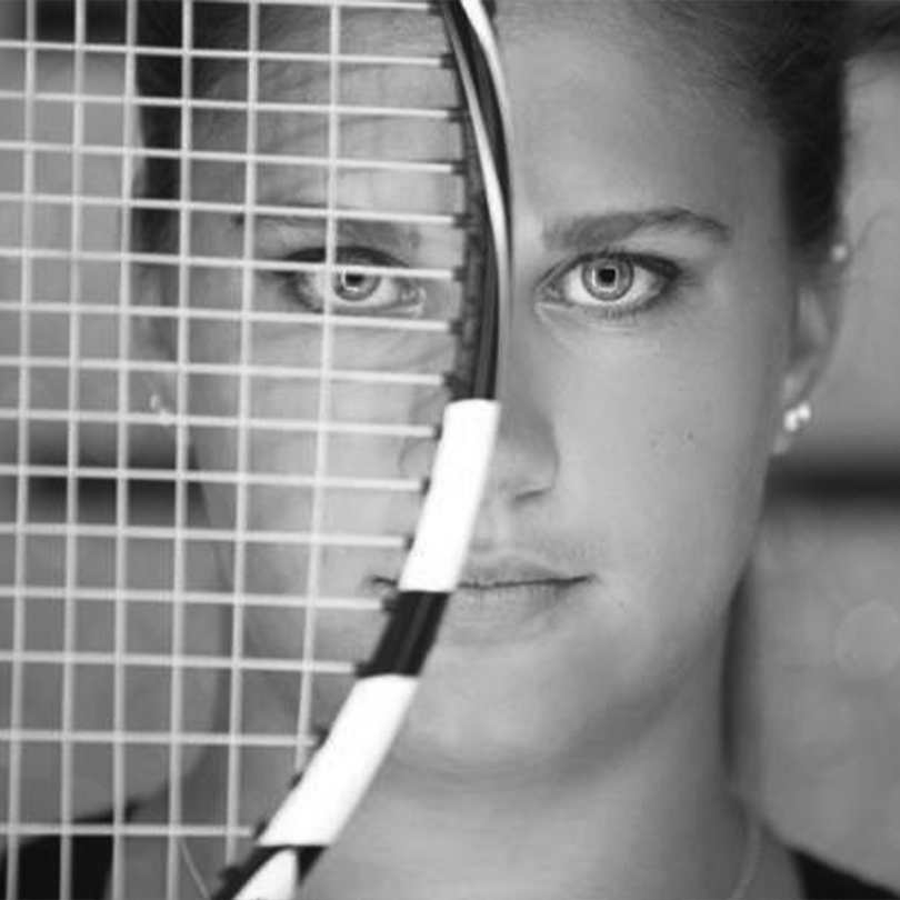 Women looking through a tennis racket